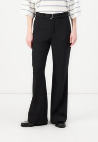 Black, high-waisted trousers with a straight-leg design, featuring a silver buckle belt and smooth fabric texture. Worn with a striped top.