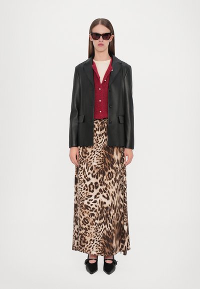 Black leather blazer over a burgundy cardigan, paired with a leopard print maxi skirt and black flats featuring bow accents. Brown sunglasses.