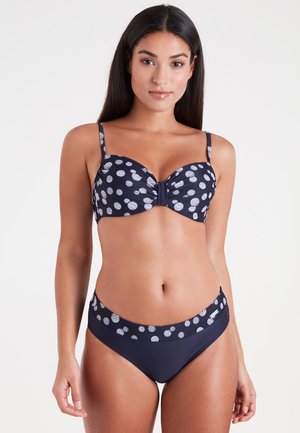 Navy bikini set with polka dot pattern. Bra features underwire and adjustable straps; high-waisted bottom with contrasting waistband.