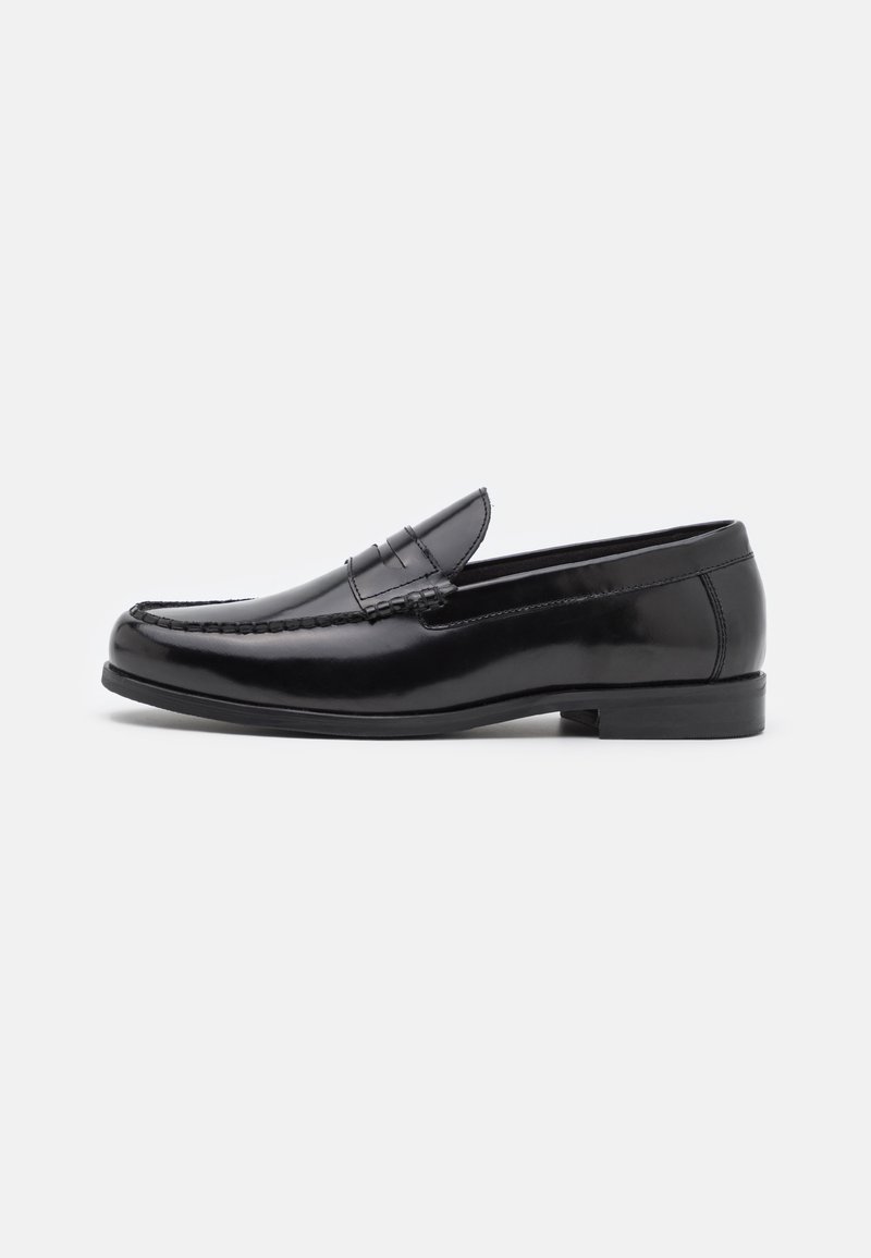 Mocassins de couro preto com bico arredondado, costura decorativa e um salto baixo. Textura suave com um brilho subtil. Design clássico sem adornos.