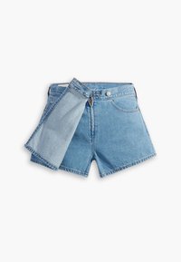 Pantalones cortos de mezclilla en azul claro con un dobladillo vuelto y un panel de tela adicional adjunto, que muestra un contraste en textura y color.