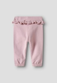 Leggings en coton rose avec un volant froncé à la taille, des poignets élastiques et une texture lisse, conçus pour le confort et la liberté de mouvement.