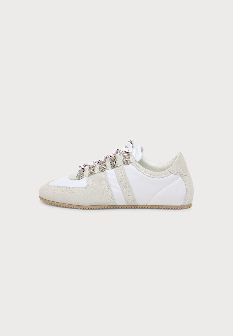 Baskets blanches à profil bas avec des accents en daim beige, semelle en caoutchouc zigzag et œillets métalliques décoratifs avec des lacets blancs à motifs.