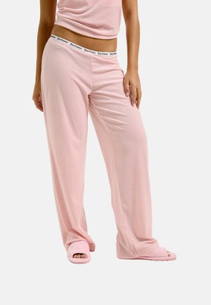 Lichtroze geribbelde loungebroek met een zachte textuur en een elastische tailleband. Gecombineerd met bijpassende lichtroze open teen pantoffels.