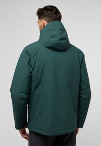 Veste à capuche vert foncé avec une texture lisse et mate. Présente une coupe décontractée, des épaules sans coutures et des détails de couture subtils.