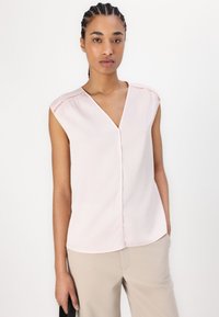 Blusa senza maniche di un delicato rosa chiaro con scollatura a V, caratterizzata da sottili accenti perforati sulle spalle. Tessuto morbido e vestibilità rilassata.
