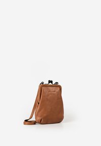 Braune Leder-Umhängetasche mit abgerundeter rechteckiger Form, schwarzem Verschluss und verstellbarem Riemen vor weißem Hintergrund.