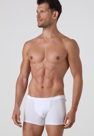 Boxer brief in cotone bianco con design senza cuciture, vita elasticizzata e una vestibilità aderente che esalta la forma. Tessuto liscio e leggero.