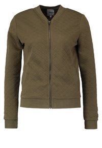 Olivgrön vadderad bomberjacka med dragkedja fram, ribbade ärmmuddar och nederkant. Har en enkel design och texturerad yta.