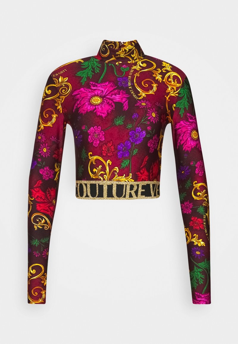 Long-sleeve cropped turtleneck with bright pink, purple, and red floral and gold scroll patterns on a dark burgundy background.