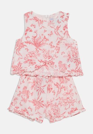 Conjunto de duas peças com uma blusa sem mangas e calções. Tecido branco com padrão floral vermelho. Bordas com pregas nas mangas e na bainha.
