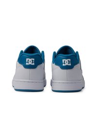 Vita sneakers med blå accenter, med en slät läderöverdel, vadderad tunga och texturerad krage. DC-logotyp synlig på hälen.