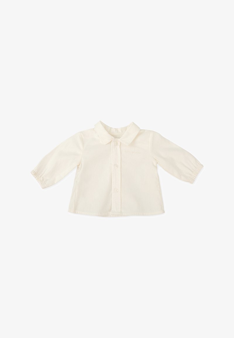 Camisa de algodón color crema con cuello, frente abotonado y mangas largas con puños fruncidos. Diseño liso, textura ligera.