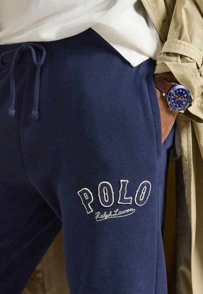 Námornícke tepláky s nastaviteľným pásom na šnúrku, na ľavej nohe vyšívané biele logo "POLO Ralph Lauren". Hladká tkanina z bavlnenej zmesi.