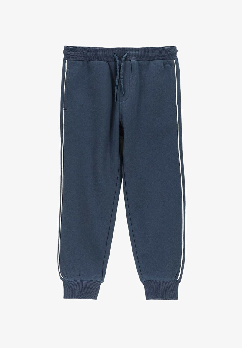 Granatowe spodnie dresowe z białymi paskami po bokach, elastycznym paskiem w talii z regulacją na sznurek, kieszeniami po bokach oraz ściągaczami przy kostkach.