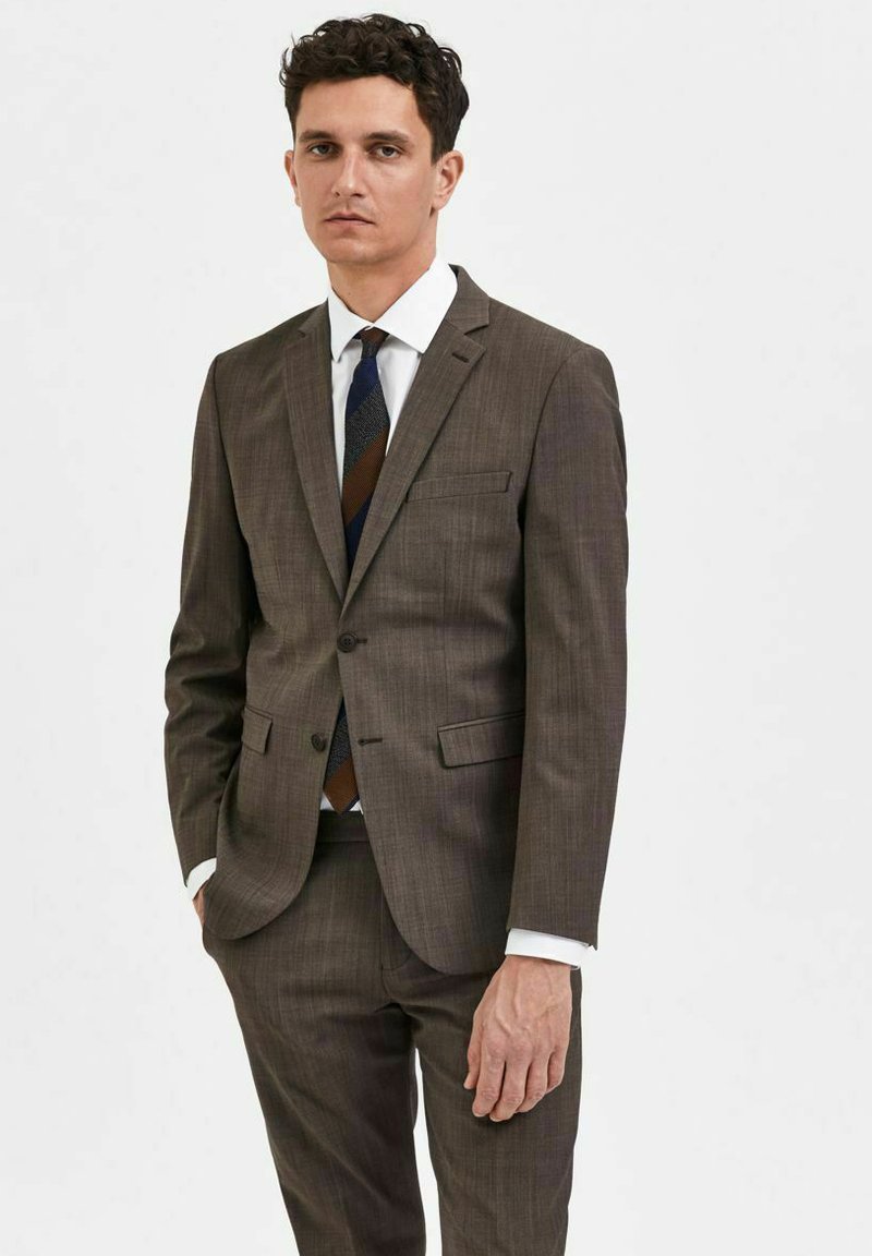 Bruin gepatterneerd pak met een single-breasted jasje en notch revers. Witte dress shirt en een meerkleurige gestreepte stropdas. Slim fit ontwerp.