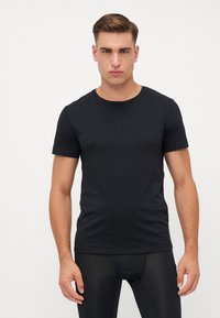 Schwarz Baumwoll-T-Shirt mit Rundhalsausschnitt und kurzen Ärmeln, taillierte Passform, glatte Textur und minimalistischer Stil.