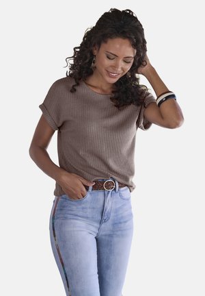 Top corto a maniche corte marrone a coste abbinato a jeans chiari a vita alta, con una cintura intrecciata marrone e dettagli a strisce laterali multicolori.