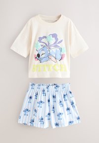 Kremowa koszulka z krótkim rękawem z kolorową grafiką Sticha i żółtym nadrukiem, zestawiona z niebieskimi szortami w paski z nadrukami Sticha.