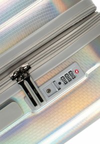 Holographischer Koffergriff, doppelte Reißverschlüsse, silberne Beschläge, Kombinationsschloss, strukturierte Oberfläche mit Rautenmuster und glatte Akzente.