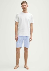 Witte katoenen t-shirt gecombineerd met blauwe gestreepte shorts. De shorts hebben een relaxte pasvorm en een zachte textuur, geschikt voor casual dragen.