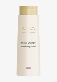 Fles AHAVA Mineral Shampoo; cilindrisch, matte crème-afwerking, gouden accenten, voorlabel toont productnaam in zwarte en roze tekst.