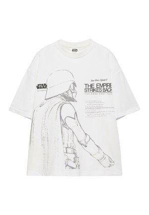 Valkoinen Star Wars -t-paita, jossa harmaasävyinen luonnos kypäräisestä hahmosta ja teksti "The Empire Strikes Back" edessä.