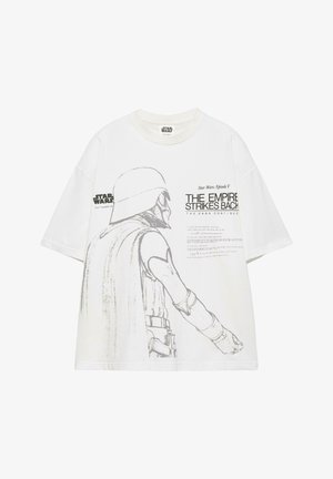 Tricou alb Star Wars cu o schiță în tonuri de gri a unui personaj cu cască și textul „The Empire Strikes Back” pe față.