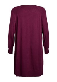 Haljina od mekane pletene tkanine dugih rukava, u boji krvi, s opuštenim krojem, zaobljenim rubom, rebrastim manšetama i bočnim prorezima.