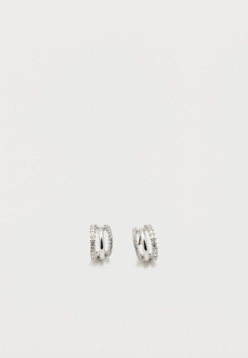 Srebrni uhani v obliki obročev z dvema trakoma, pri čemer je en trak okrašen z majhnimi prozornimi dragimi kamni, prikazani na belem ozadju.