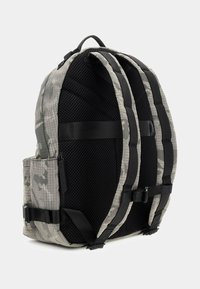 Grauer Camouflage-Rucksack mit schwarzen Netzriemen und Akzenten. Verfügt über eine gepolsterte Rückseite und verstellbare Seitenriemen für Unterstützung und Komfort.