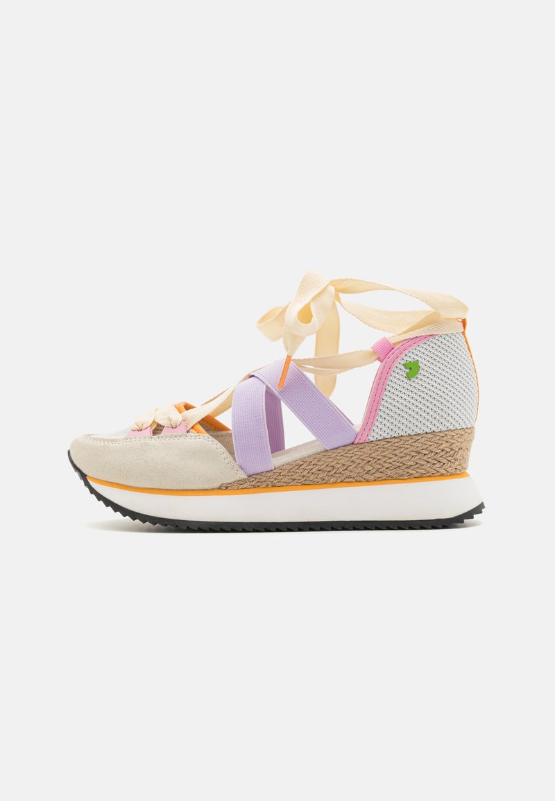 Zapatilla cuña de ante beige, con bandas elásticas moradas y un talón trenzado. Presenta un panel lateral de malla y una suela de goma negra.