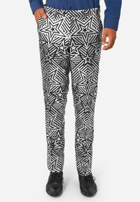 Pantalones en blanco y negro con un audaz patrón de estrellas y rayas, corte ajustado, fabricados en tejido ligero, con bolsillos laterales y una cinturilla.