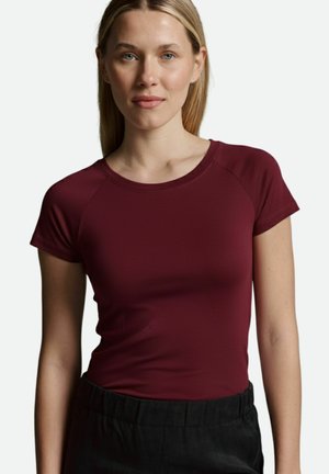 Bordeauxfarbenes Kurzarmoberteil mit Rundhalsausschnitt und Raglanärmeln, aus einem glatten, dehnbarem Stoff hergestellt. Mit einer taillierten Silhouette gestaltet.