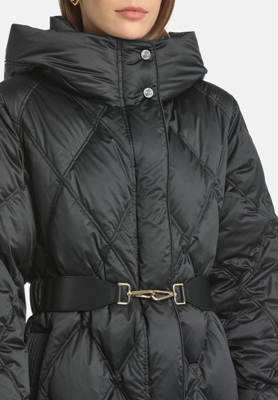 Jacheta puffer neagră are un design cu o însușire de tip diamante, guler înalt și o curea lată neagră cu o cataramă din aur. Textură netedă și lucioasă.