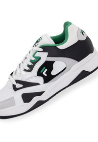 Zapatilla deportiva blanca con acentos en negro y gris, detalles en verde, malla texturizada, cuello acolchado y suela con patrón.
