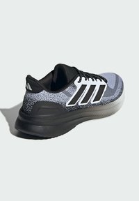 Chaussure de sport noire et grise avec un dessus en tricot texturé, accent trois rayures blanches et une semelle en caoutchouc noir solide.