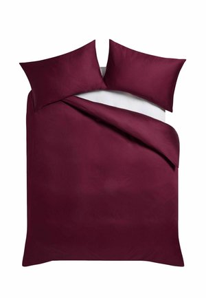 Doppelbett mit burgunderrotem Bettbezug und passenden Kissenbezügen auf weißem Laken, von oben gezeigt mit einer Ecke leicht zurückgefaltet.