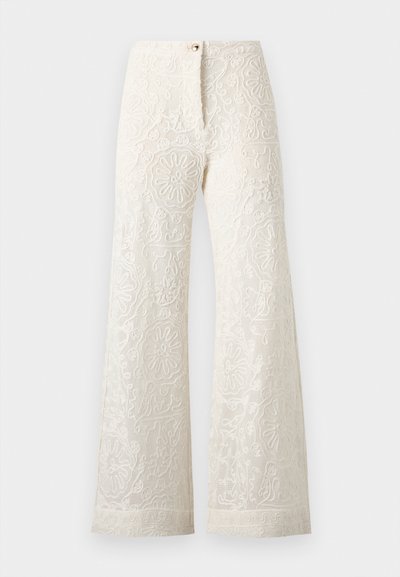 Pantalon blanc taille haute à jambes larges avec une broderie en dentelle florale délicate et une fermeture à boutons à l’avant sur un fond uni.