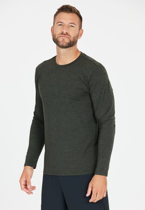Mørkegrøn langærmet skjorte med et tekstureret mønster, rund halsudskæring og slim fit, parret med navy blå træningsbukser.