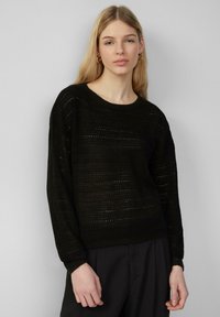 Zwarte gebreide trui met een losse fit, met een textuurpatroon en lange mouwen. Ronde halslijn en geribde manchetten.