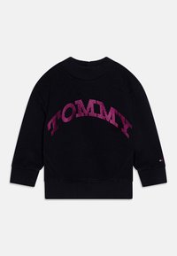 Črna kapuca z rebrastim ovratnikom. Opremljena je z živahnim rožnatim dizajnom "TOMMY" ter ima rebraste manšete in spodnji rob za boljše prileganje.