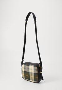 Mala crossbody em pele preta com um padrão xadrez em creme, verde e amarelo. Apresenta um fecho em zíper e uma alça ajustável. Forma retangular.