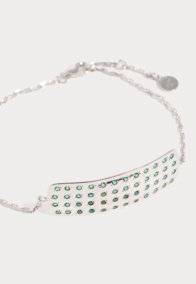 Ασημένιο βραχιόλι αλυσίδας με ορθογώνια πλάκα διακοσμημένη με πολλούς μικρούς πράσινους πολύτιμους λίθους σε σχηματισμό πλέγματος, με κούμπωμα και ρυθμιζόμενους κρίκους ορατούς.