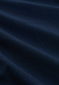 Ύφασμα σε ναυτικό μπλε με  ομαλή υφή, που παρουσιάζει λεπτές πτυχώσεις και ομοιόμορφο, ομοιόμορφο φινίρισμα χωρίς ορατά σχέδια ή μηχανισμούς.