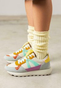 Baskets de sport avec un mélange de couleurs beiges, oranges, menthe et violettes. Fabriquées en cuir et en suède, avec des lacets blancs et une semelle texturée.