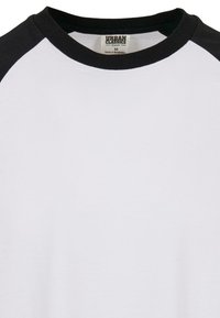Weißes T-Shirt mit schwarzen Raglanärmeln. Weiches Material aus Bio-Baumwolle, Rundhalsausschnitt. Tag mit "Urban Classics" und Größe "M."