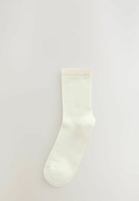 Čarape od mješavine pamuka u off-white boji, s rebrastom teksturom, standardne dužine do članka i ojačanim prstima s glatkim rubom.