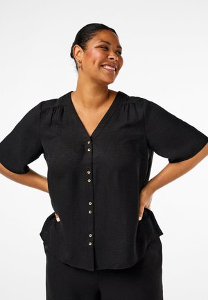 Blusa nera a scollo a V con maniche corte, caratterizzata da bottoni dorati lungo il davanti e un tessuto texturizzato. Orlo leggermente curvo e vestibilità rilassata.