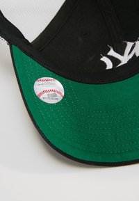 Căciulă de baseball neagră și verde, cu o vizieră curbă, un autocolant etichetat "Major League Baseball Oficial" și text alb brodat.